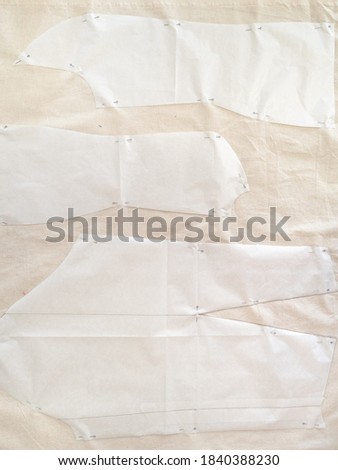 top view of paper pattern layouts of dress on calico fabric