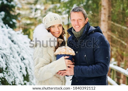 Close up image of man offering flower box of golden roses to beautiful young woman