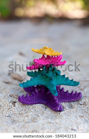 Color starfishes on white sandy beach. 