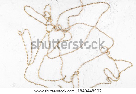 Christmas garland on white concrete background. Golden christmas decorations on stone cement surface with copy space.