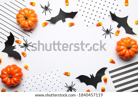 Halloween paper bats with candies, pumpkins and spiders on white background