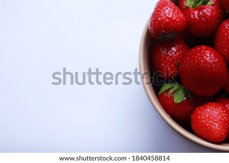 Strawberries in a plate on a light background, diet