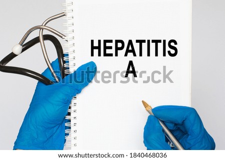 The doctor's blue - gloved hands show the word HEPATITIS A - . a gloved hand on a white background. Medical concept. the medicine