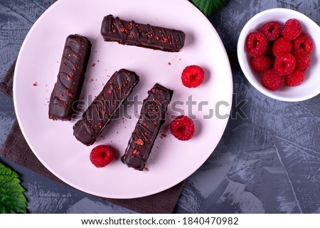 Chocolate glazed cottage cheese bars and raspberry on the ceramic plate. Soviet and Russian cuisine dessert Royalty-Free Stock Photo #1840470982