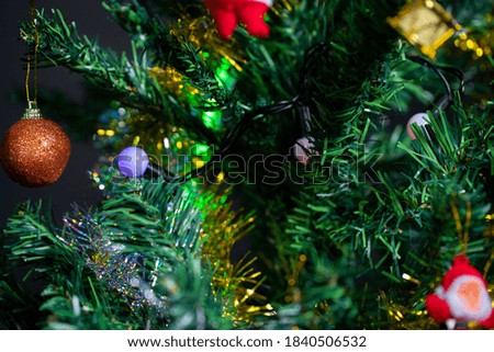 colorfully decorated christmas tree details. Santa hat. Colorful balls of light and colorful decors