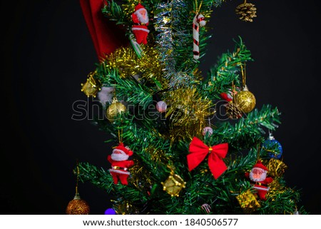 colorfully decorated christmas tree details. Santa hat. Colorful balls of light and colorful decors