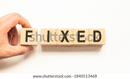 Word fixed. Wooden small cubes with letters isolated on white background with copy space available.Business and finance concept
