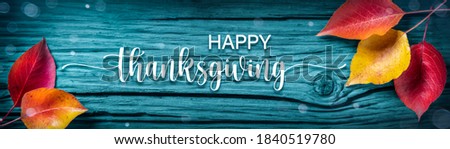 "Happy Thanksgiving" Message On Rustic Blue Harvest Table Background Decorated With Leaves 