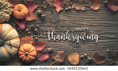 
"Happy Thanksgiving" Message On Rustic Harvest Table Background Decorated With Pumpkins Acorns And Leaves
