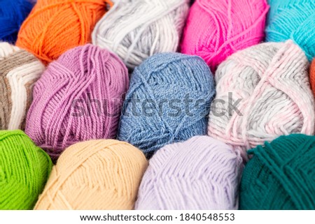 The stack of colorful knitting yarn clews close up picture.