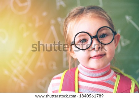 The first day at school. A little school girl stands at the chalk board. High quality photo