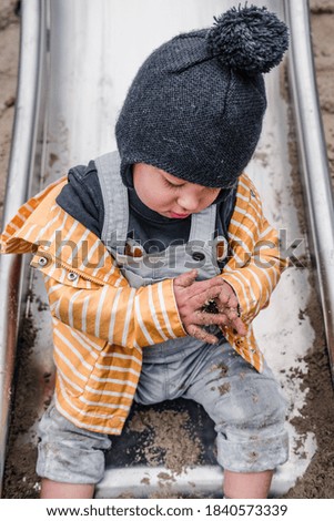 Littl boy playing with sand