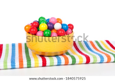 A bowl of colorful gumballs on a vibrant napkin.