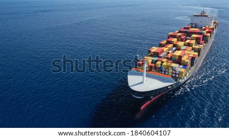 Aerial drone photo of huge container tanker ship carrying truck size colourful containers in deep blue open ocean sea Royalty-Free Stock Photo #1840604107