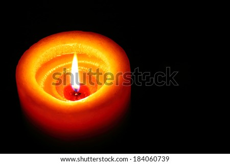 Orange Candle Shining In The Dark With Black Background Space On The Right