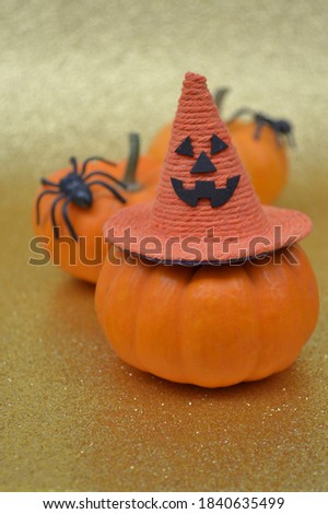Halloween pumpkin with witch hat on a gold glitter background. Creative concept.