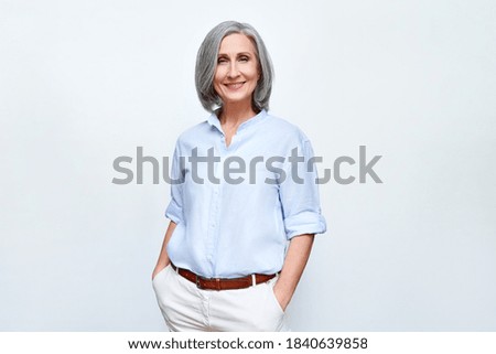 Smiling confident middle aged business woman standing isolated on white background. Old senior businesswoman, 60s grey haired lady professional female manager, leader looking at camera, copy space.