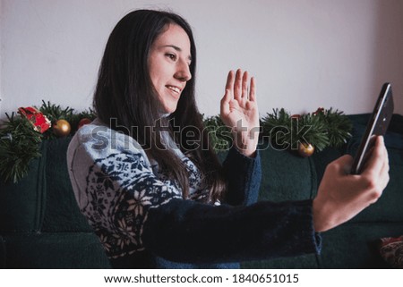 A girl waving while doing a video call on her phone