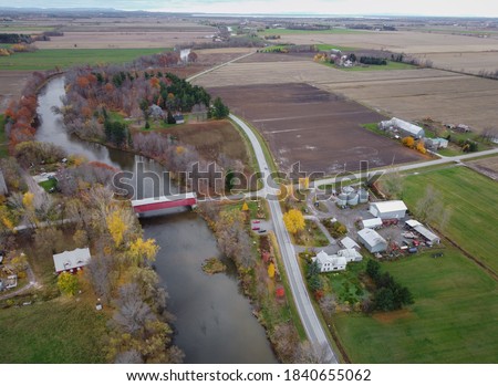 View on a farms and the Rivieres covered bridge. The  one of the oldest covered bridge in Quebec and Canada . Picture is made in autumn by drone