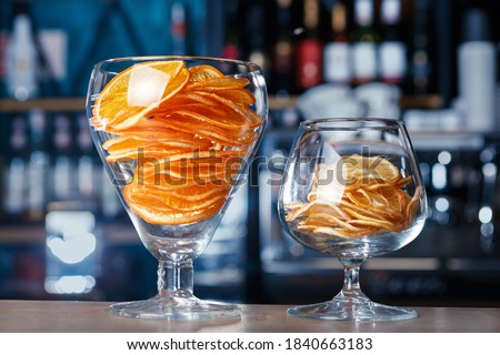 Dried oranges and lemons in large glasses on the bar, Soft focus, selective focus