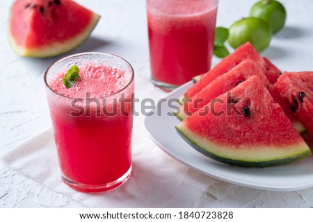 Watermelon smoothie topping with fresh mint leaves on wood background