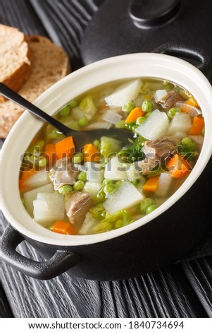Tradtional Scottish Harvest Broth called Hotch Potch with lamb meat close-up in a pot on the table. Vertical
