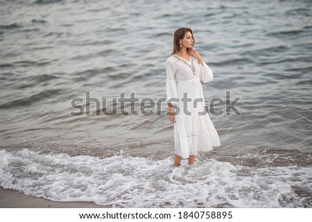 beautiful woman in white dress by the sea