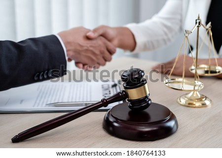 shake hand Professional male lawyers work at a law office There are scales, Scales of justice, judges gavel, and litigation documents. Concepts of law and justice.