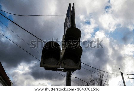 Traffic light and road sign. Not working traffic light with a pedestrian crossing against the sky. Grunge, dark, urban