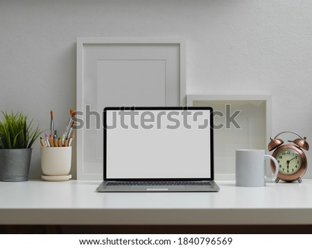 Close up view of home office interior design with laptop, paint brushes and decorations, clipping path