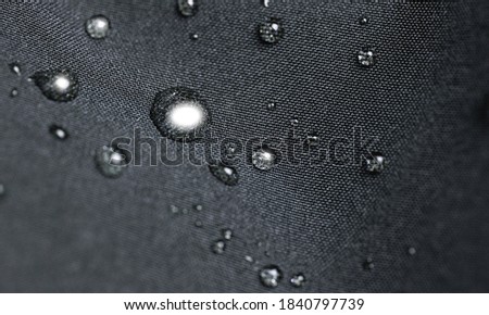 Waterproof fabric, clothing with water drops. Rain drops on water resistant textile waterproof coating Royalty-Free Stock Photo #1840797739