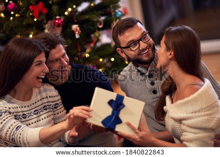 Group of friends with presents celebrating Christmas at home