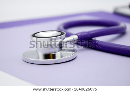 Stethoscope, stethophonendoscope on a purple background . Measurement of elevated pressure. Treatment to hypertensions. Medical flatly. Color of year 2022 Very peri