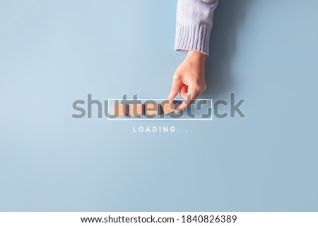 Loading, hand putting wood cube in progress bar. Royalty-Free Stock Photo #1840826389