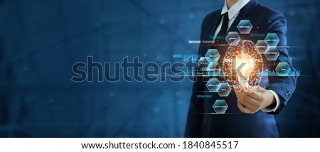 Businessman holding light bulb Illuminate and brain with word of design thinking for business growth, Creativity and innovation, New idea and position of branding, Business design thinking concept.