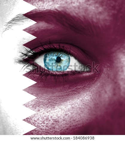 Woman face painted with flag of Qatar