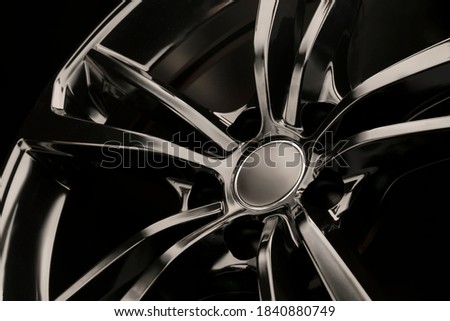 Black Gloss alloy wheel on a dark background. Stylish and expensive. Close-up of spoke elements, Royalty-Free Stock Photo #1840880749