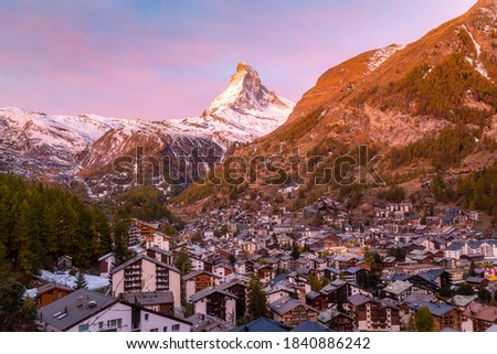 The Swiss village of Zermatt in Valais in autumn at sunrise, with the Matterhorn and the Alpine mountain range in the background.