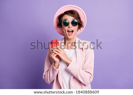 Photo of curly surprised student lady wear vintage outfit glasses holding gadget hands arms open mouth isolated violet color background