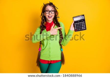 Photo of amazed girl messy hairdo point finger calculator wear shirt trousers isolated yellow color background