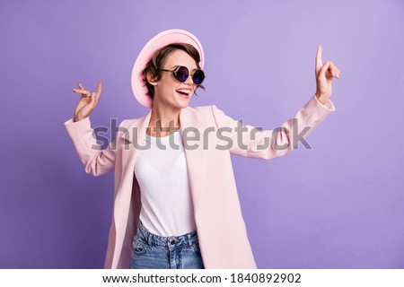 Photo of excited dance disco hit young brunette woman wear cap glasses coat isolated on purple color background