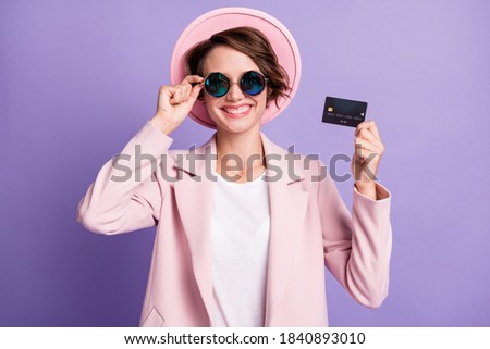 Photo of curly cute cheerful woman wear casual vintage blazer glasses holding wireless credit card arm glasses isolated purple color background