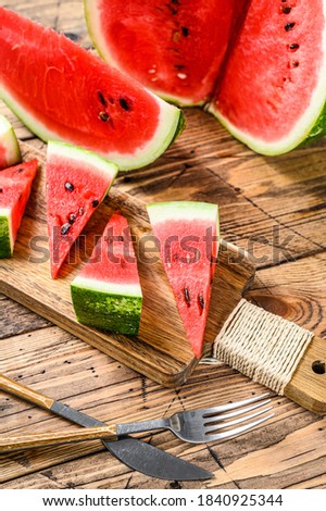 Heap of fresh red sliced watermelon. Wooden background. Top view