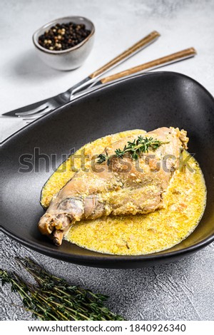 Stew with hare legs with rosemary and garlic. Gray background. Top view