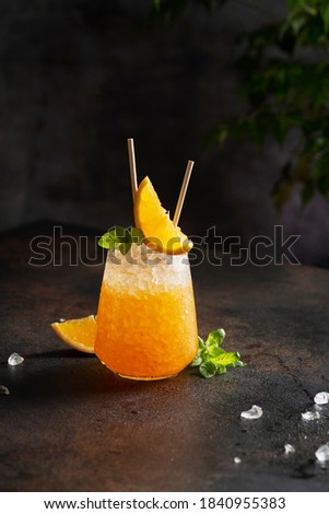 Fresh cold cocktial with orange, crushed ice and mint, selective focus image and bar concept