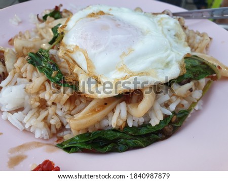 Stir-fried basil, squid, fried egg and steamed rice, a delicious quick dish.