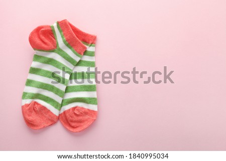 pair of colorful bright socks on pink background with copy space 