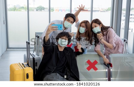 Group of passengers in the airport take a selfie before traveling