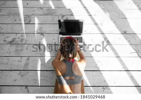 Woman doing online yoga classes indoors