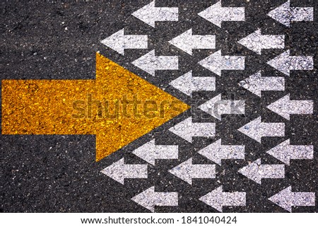 Different thinking and Business and technology disruption concept. Yellow big arrow opposite  direction with white arrow on road asphalt.  Royalty-Free Stock Photo #1841040424